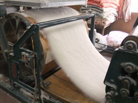 ⑤　切れた何層にも重なる綿は次の工程へ